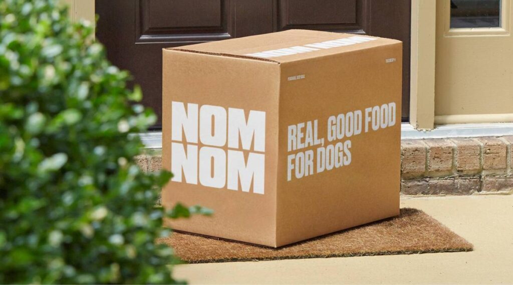 Caja de entrega de comida para perros Nom Nom en un porche delantero